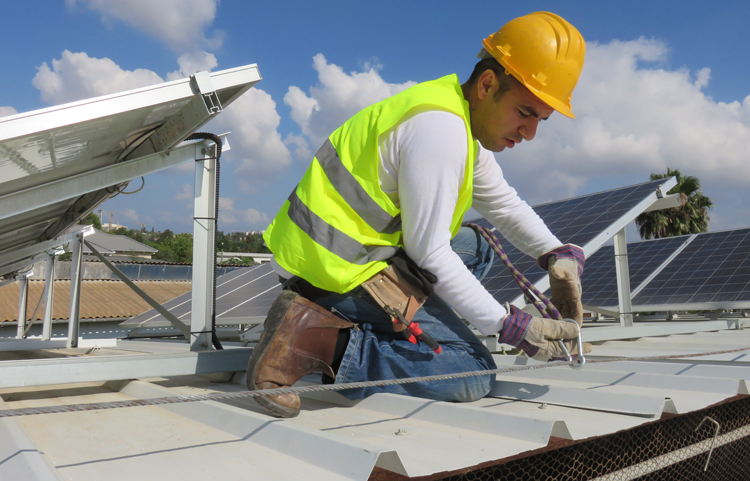 Homme installant des panneaux solaires